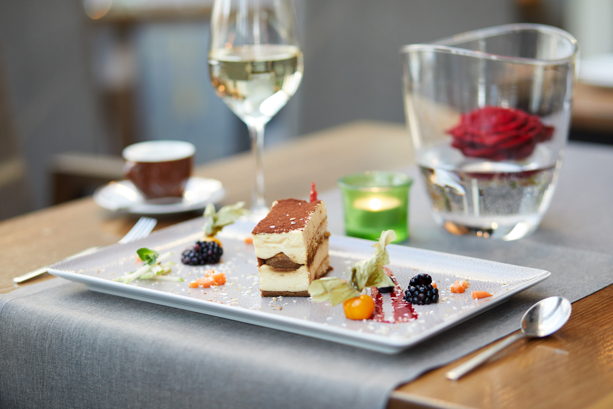 Gedeckter Tisch mit Teller und Weißwein